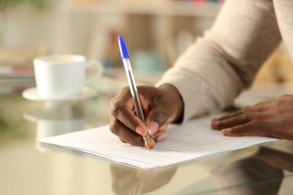african american hand with pen writing on paper